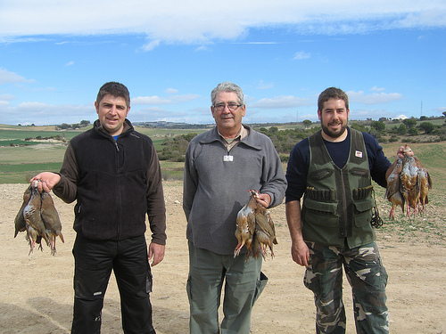 Paco Gamero, entre los hermanos Jaume y Jordi Corsa, un día de cacería de la perdiz roja. Foto de los tres sosteniendo perdices recién cazadas.